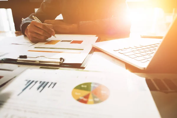 Mano del hombre con la pluma whit informe de negocios y el uso de ordenador portátil para el análisis de datos financieros — Foto de Stock