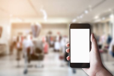 Boş beyaz ekran ve Pazar ya da kıyafet Dükkanı ile beyaz cep telefonu tutan el mockup görüntü arka plan bulanıklık