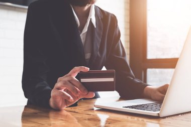 Online ödeme, kredi kartı tutan ve vintage ile online alışveriş için dizüstü bilgisayar kullanan iş kadının elleri sesi filtre.