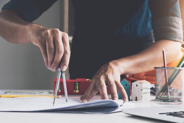 Yakın çekim mimari çizim planı üzerinde mavi baskı mimar araçlar onun işyeri ve ev modeli ile