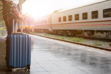 Klasik tren bekleyen ve mavi çanta için yaz aylarında seyahat etmek tren istasyonunda tutan güzel kadın hippi. Seyahat kavramı.