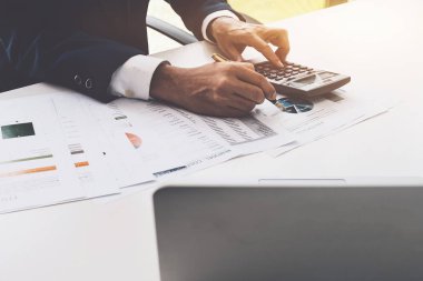 Grafik grafik hesap makinesi ve sayıları hesaplamak için dizüstü bilgisayar kullanırken işaret eden işadamı kalem. Muhasebe, muhasebe, Fintech kavramı. 