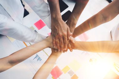 Genç insanların ellerini birleştirirken üst bakış açısını kapatın. Birlik ve takım çalışması gösteren el yığınına sahip arkadaşlar.