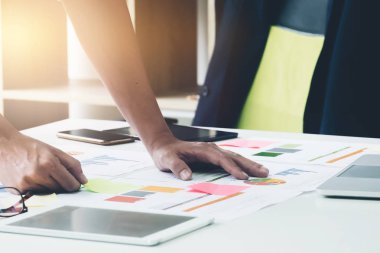 İş adamı ile Evrak Çantası'nı ve telefon, dizüstü bilgisayar ve dijital tablet işyeri üzerinde konsantre seyir belgeler üzerinde çalışan eller yukarı kapatın