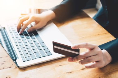 Online ödeme, kredi kartı tutan ve vintage ile online alışveriş için dizüstü bilgisayar kullanan iş kadının elleri sesi filtre.