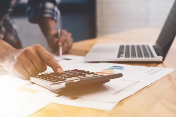 Empresário usando uma calculadora para calcular os números do relatório financeiro de negócios em sua mesa em um escritório. Conceito de negócio — Fotografia de Stock