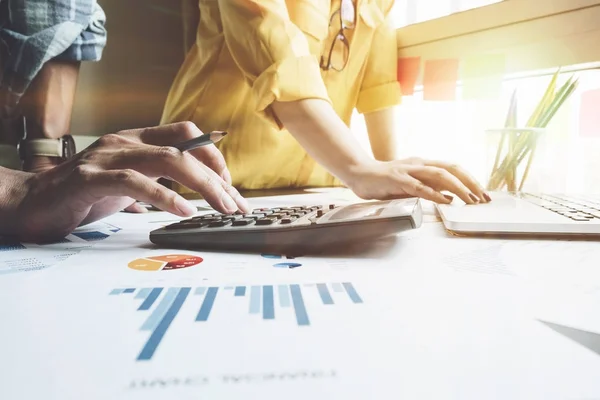 Sosyal ağ diyagramına sahip dizüstü bilgisayar ve tablet kullanan bir iş adamı ve masadaki verileri sabah ışığı konsepti olarak tartışan iki meslektaşı.