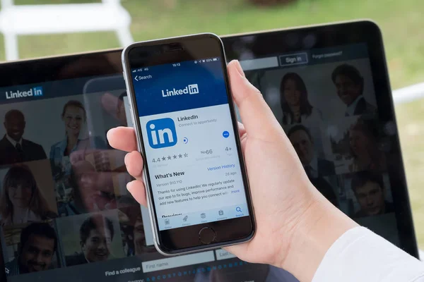 Chiang Mai, Tayland Jan 07 2018: bir iphone 6s sırasında tutan işadamı ekrandaki bir sosyal ağ hizmeti LinkedIn indirin. iPhone 6s oluşturuldu ve Apple Inc tarafından geliştirildi.