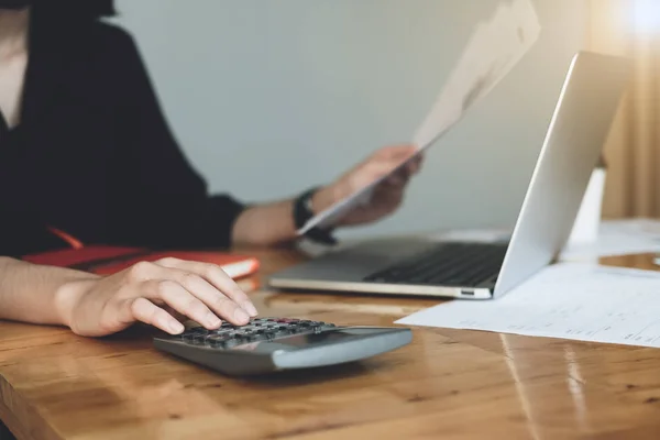 İş yeri verilerini, muhasebe belgelerini ve ofisteki dizüstü bilgisayarları, iş konseptini hesaplamak için hesap makinesi üzerinde çalışan iş adamı ya da muhasebecinin el kalemini kapat