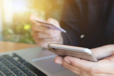Çevrimiçi ödeme, akıllı telefon tutan adamın elleri ve online alışveriş için kredi kartı kullanmak..