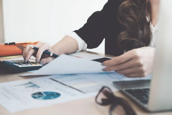 Close up van accountant hand met pen bezig met calculator voor het berekenen van zakelijke gegevens, boekhouding document en laptopcomputer op kantoor, bedrijfsconcept — Stockfoto