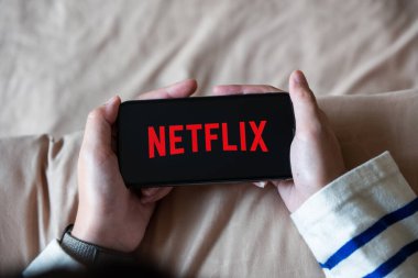 CHIANG MAI, THAILAND - 06 Nisan 2020: Evde iPhone X açık Netflix uygulaması kullanan kadın. Netflix, dünya çapında bir dizi ve film sağlayıcısıdır..