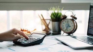 Finans, vergi, muhasebe, istatistik ve analitik araştırma kavramını hesaplamak için iş kadını hesap makinesi ve dizüstü bilgisayar