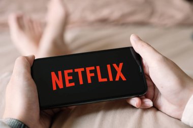 CHIANG MAI, THAILAND - 06 Nisan 2020: Evde iPhone X açık Netflix uygulaması kullanan kadın. Netflix, dünya çapında bir dizi ve film sağlayıcısıdır..