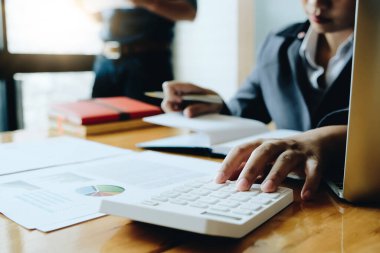 İş kadını, ofis ve iş geçmişinde, vergi, muhasebe, istatistik ve analitik araştırma kavramında matematik finansmanı için hesap makinesi kullanıyor.