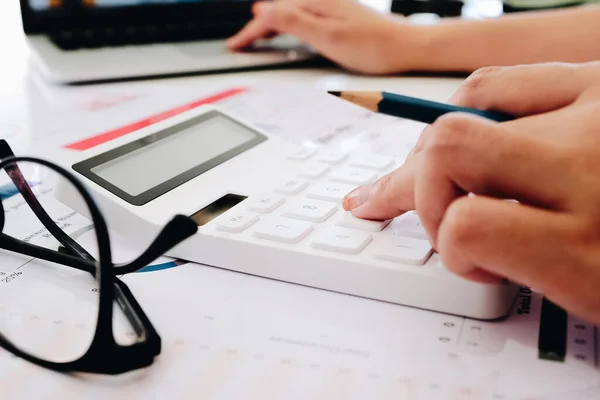 Закрыть бизнес-женщина с помощью калькулятора и ноутбука для математики финансов на деревянном столе в офисе — стоковое фото