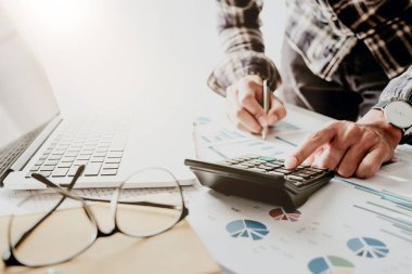 Ofisteki mali hesapları hesaplamak için dizüstü bilgisayarla çalışan iş adamı veya muhasebeci