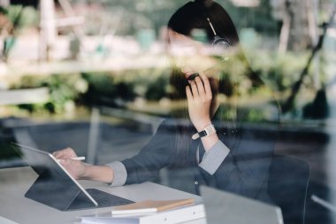 Bir çağrı merkezinde dizüstü bilgisayarla çalışan, kulaklık takan genç, arkadaş canlısı bir kadın ajan..