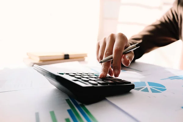 Close-up van zakenman of accountant hand holding pen werken op rekenmachine om zakelijke gegevens te berekenen, — Stockfoto
