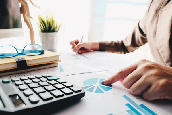 Close up of accounting hand holding pen working on calculator to calculation business financial reports — Stock fotografie