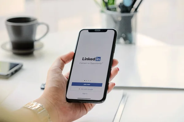 CHIANG MAI, THAILAND, MAR 7, 2020: Een vrouw houdt Apple iPhone Xs met LinkedIn-applicatie op het scherm. — Stockfoto