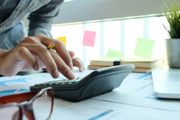 Close-up van zakenman of accountant hand holding potlood werken aan rekenmachine voor de berekening van financiële gegevens rapport, — Stockfoto