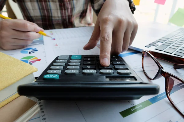 Close up Empresária usando calculadora e laptop para fazer finanças matemáticas em mesa de madeira no escritório — Fotografia de Stock