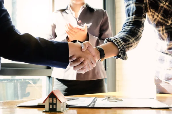 Agente de bienes raíces y clientes estrechando las manos juntos celebrando contrato terminado después de sobre el seguro de hogar —  Fotos de Stock