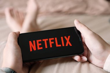 CHIANG MAI, THAILAND - 06 Nisan 2020: iPhone X açık Netflix uygulaması kullanan kadın. 
