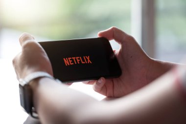 CHIANG MAI, THAILAND, 17 Kasım 2019: Akıllı Telefon Netflix X 'i tutan kadın.