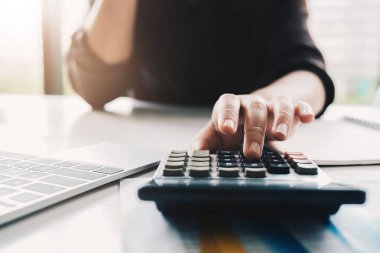 Matematik finansmanı için hesap makinesi ve dizüstü bilgisayar kullanan İş kadınını kapat