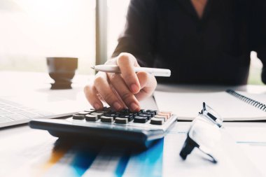 Matematik finansmanı için hesap makinesi ve dizüstü bilgisayar kullanan İş kadınını kapat 