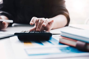 Matematik finansmanı için hesap makinesi ve dizüstü bilgisayar kullanan İş kadınını kapat 
