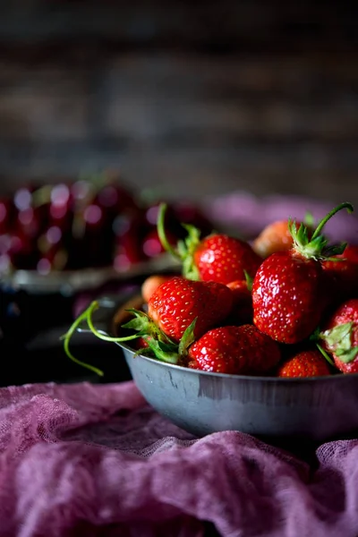 Summer red berries on a season. Red strawberry in on a wooden table. A still life from red summer berries