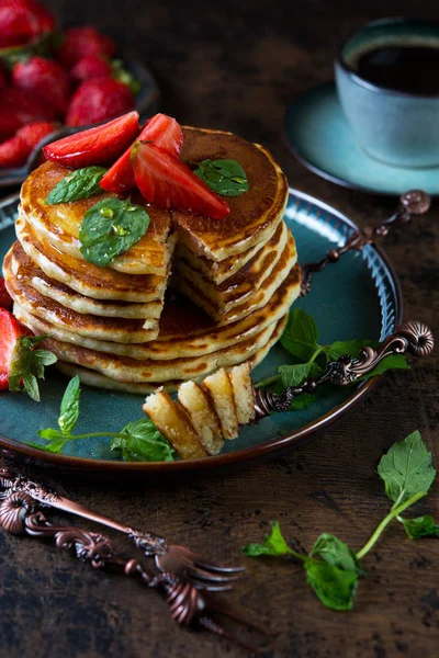 Classic American Breakfast pancake with honey and berries. Still life of lush pancakes, honey and strawberries.