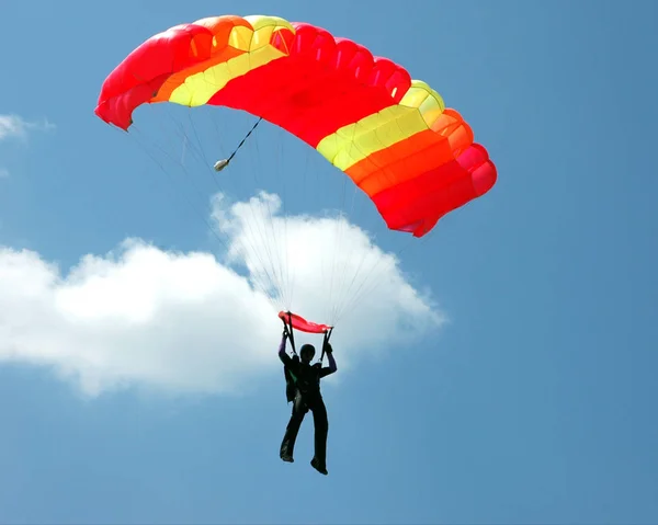 Paracaidista con paracaídas amarillo-rojo Imagen De Stock