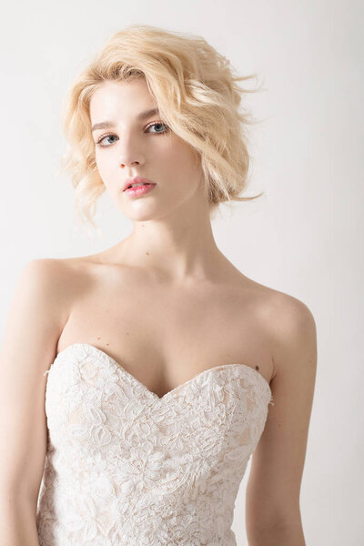 Женщина с белыми волосами в свадебном платье. Молодая блондинка с голубыми глазами. Портрет красивой блондинки. Модель моды. Женщина с идеальной кожей. Наголый макияж. Концепция модной фотографии
