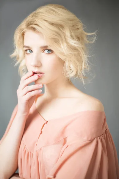 Young blonde woman with blue eyes. Portrait of a beautiful blonde girl. Fashion model. Woman with perfect skin. Woman with white hair in a pink blouse with nude makeup. Fashion photography concept — Stock Photo, Image