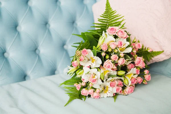 Bridal bouquet. Bridal bouquet on a blue velvet sofa.