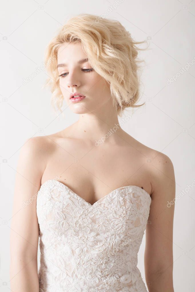 Woman with white hair in a wedding dress. Young blonde woman with blue eyes. Portrait of a beautiful blonde girl. Fashion model. Woman with perfect skin. Nude makeup. Fashion photography concept