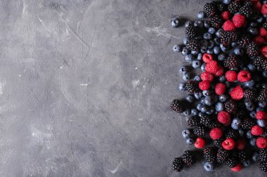 Ahududu, böğürtlen, yaban mersini gri bir arka plan soyut