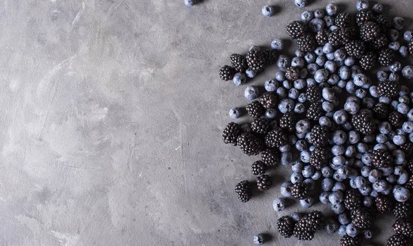 Himbeeren, Brombeeren, Blaubeeren einen grauen abstrakten Hintergrund — Stockfoto