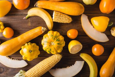 Sarı meyve ve sebze ahşap arka plan üzerinde. Renkli festival natürmort. Boşaltmak. Squash, kavun, limon, muz, biber, elma, Mısır sarı