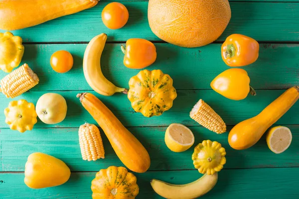 Żółte owoce i warzywa na turkus tło drewniane. Kolorowy, uroczysty, Martwa natura. Miejsce. Żółty squash, cytryny, banan, pieprz, jabłka, melon, kukurydza — Zdjęcie stockowe