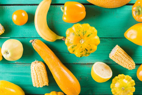 Κίτρινα φρούτα και λαχανικά σε φόντο τιρκουάζ ξύλινα. Πολύχρωμη εορταστική ζωή ακόμα. Copyspace. Κίτρινο σκουός, πεπόνι, λεμόνι, μπανάνα, πιπέρι, τα μήλα, καλαμπόκι — Φωτογραφία Αρχείου