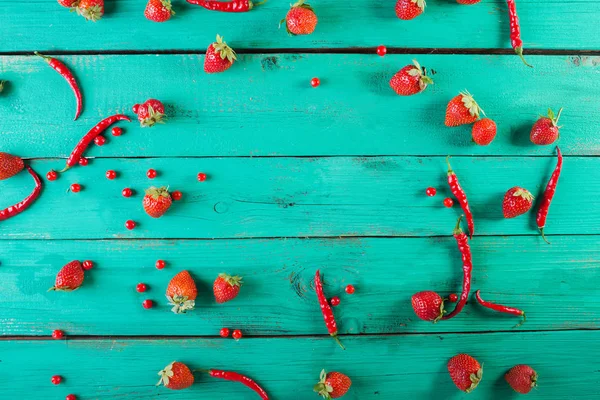 Red fruits and vegetables on a white on a wooden background. Colorful festive still life. Copyspace. Fresh strawberry. Half of grapefruit, fresh watermelon, red peppers on wooden turquoise background