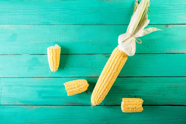 Mazorcas de maíz sobre fondo de madera turquesa — Foto de Stock