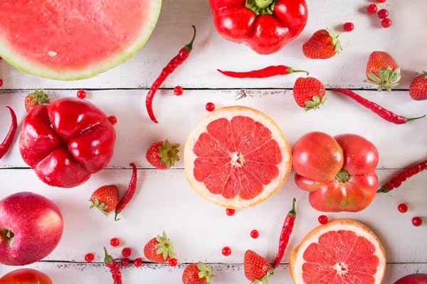 Frutas e verduras vermelhas em um branco em um contexto de madeira. Vida morta festiva colorida . — Fotografia de Stock