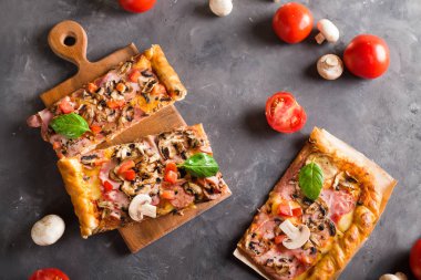 fesleğen domates ve mantarlı ahşap bir tahtada kare pizza yiyelim. Üstten Görünüm. Boşaltmak. Pizza gri masada