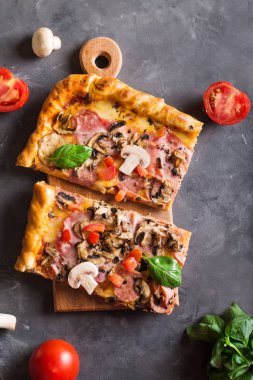 fesleğen domates ve mantarlı ahşap bir tahtada kare pizza yiyelim. Üstten Görünüm. Boşaltmak. Pizza gri masada